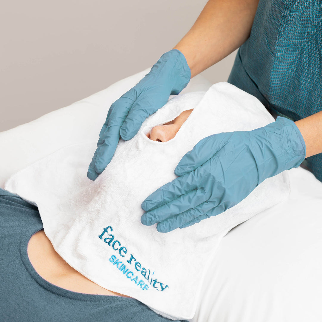 White treatment towel on client's face